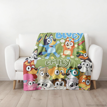 A colorful custom pet-themed throw blanket featuring Bluey and Bingo characters, draped over a white armchair in a bright room with light wood flooring.
