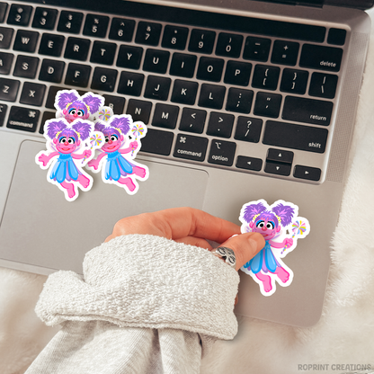 Add some fun with this Abby sticker! Perfect for party favors, crafts, or decorating notebooks, laptops, and more — the best gift for Sesame Street fans.